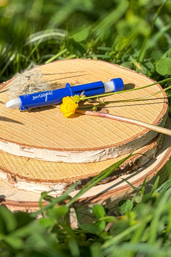 Zeckenzange auf Holzscheibe